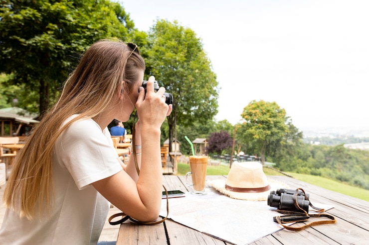 Foto gratuito vista laterale di una donna che prende una foto