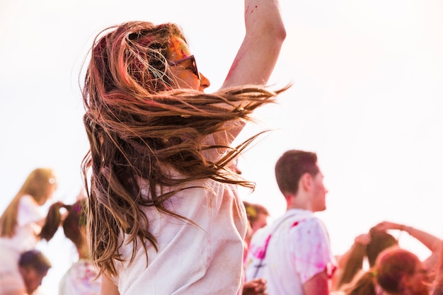 Vista laterale di una donna che si diverte mentre gioca holi