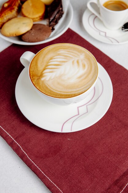 Vista laterale di una tazza di caffè e dolci