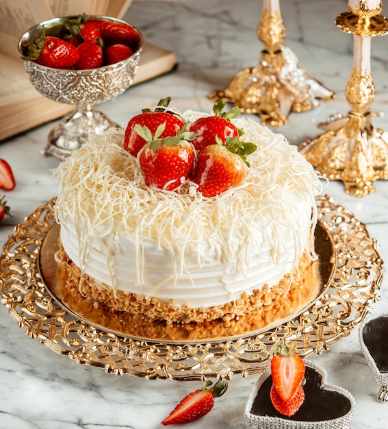 Vista laterale di una torta con fragole e briciole sul vassoio d'argento