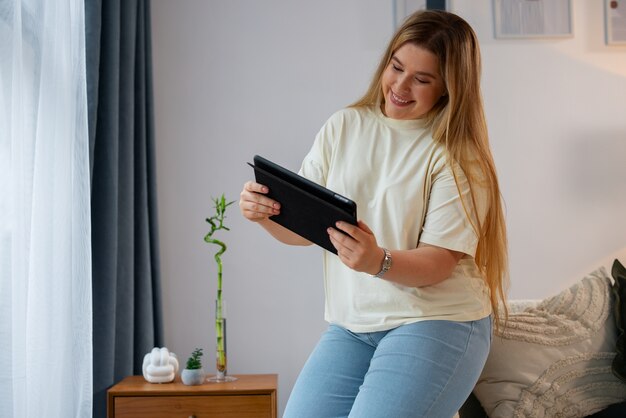 Vista laterale donna che effettua videochiamate con tablet