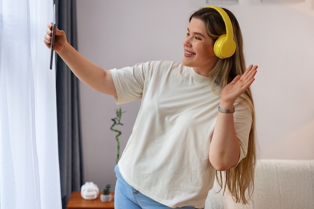 Vista laterale donna che effettua videochiamate con tablet