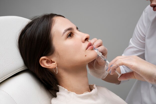 Vista laterale donna che prende i riempitivi per le labbra