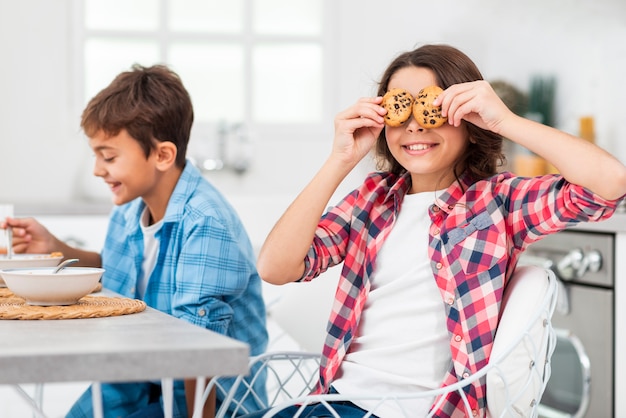 Vista laterale fratelli giocosi mentre facevo colazione