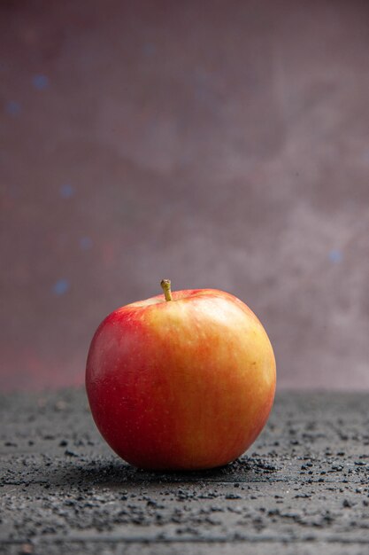 Vista laterale frutta mela giallo-rossastra su un tavolo grigio su sfondo viola