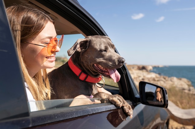 Vista laterale giovane donna e cane che vanno in viaggio