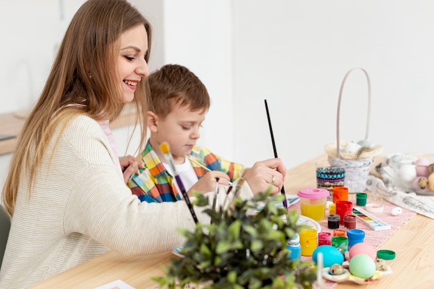 Vista laterale mamma e figlio pittura uova