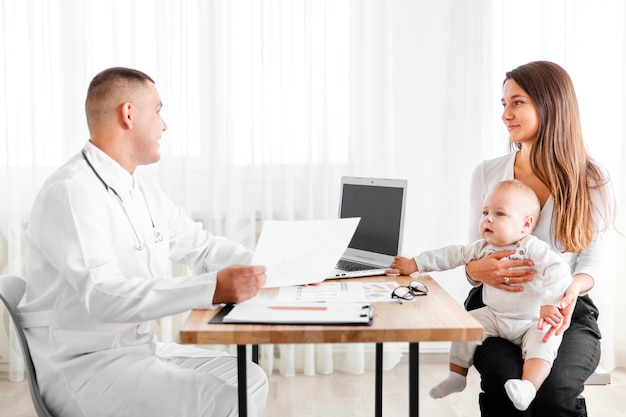 Vista laterale medico parlando con la madre di un bambino