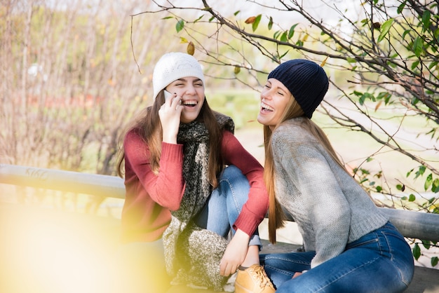 Vista laterale medio sparato a due giovani donne che chiacchieravano nel parco