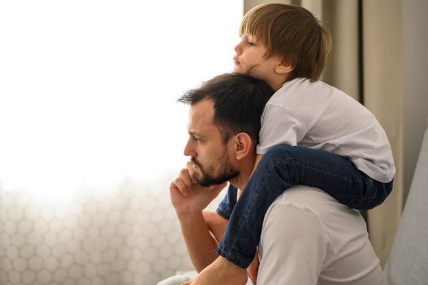 Vista laterale padre che tiene il figlio