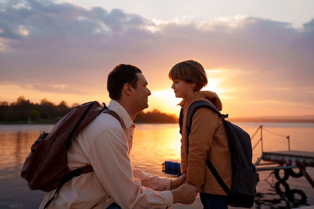 Vista laterale padre e figlio che vanno in giro su un molo