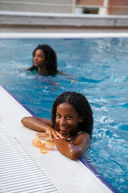 Vista laterale ragazza sorridente in piscina