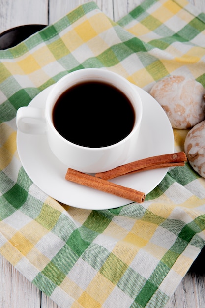 vista laterale Tazza di caffè con cannella e pan di zenzero sulla tovaglia