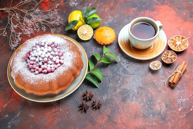 Vista laterale torta una torta anice stellato agrumi cupcake bastoncini di cannella una tazza di tè