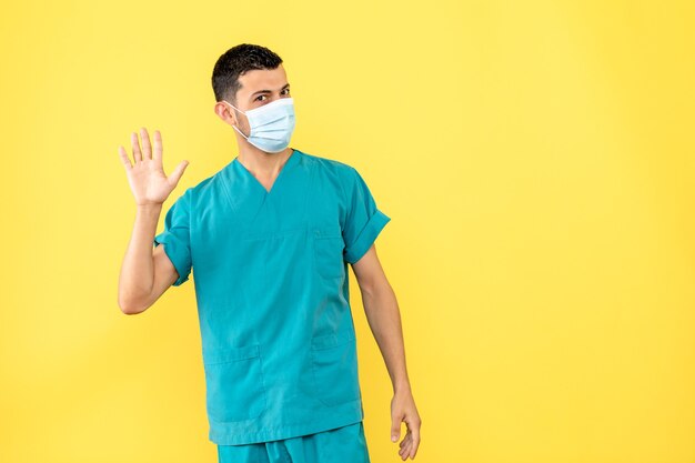 Vista laterale un dottore in maschera un dottore sta pensando di lavarsi le mani durante la pandemia di coronavirus