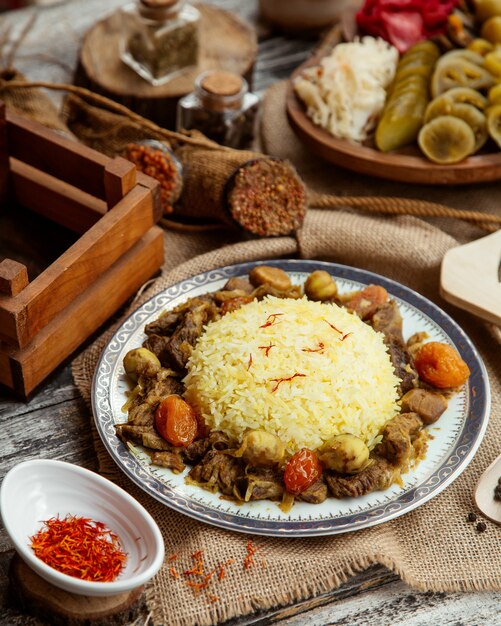 Vista laterale un piatto tradizionale azero pilaf con carne e dolci con spezie e salati
