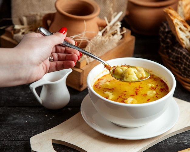 Vista laterale una ragazza mangia la zuppa di Dushbara un piatto tradizionale azero