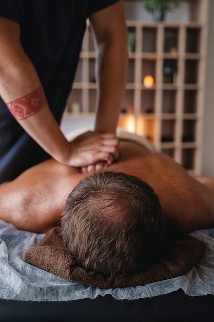 Vista laterale uomo che massaggia il paziente