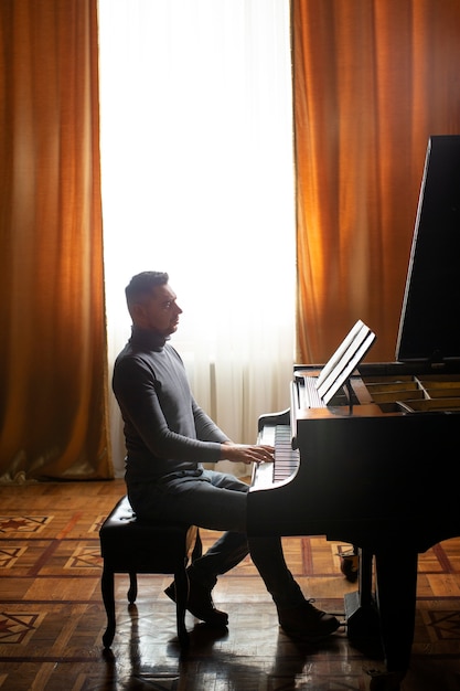 Vista laterale uomo che suona il pianoforte