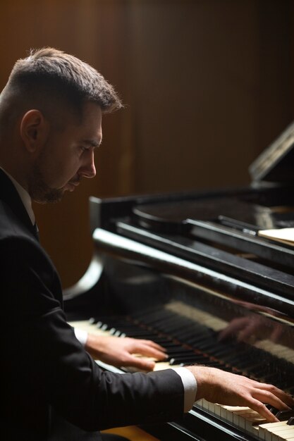 Vista laterale uomo che suona il pianoforte