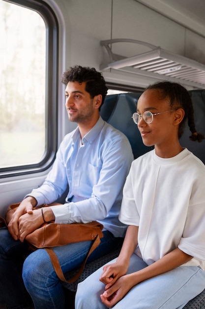 Vista laterale uomo e ragazza che viaggiano in treno