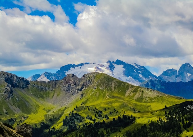 Vista mozzafiato sui bellissimi campi erbosi e montagne sotto le nuvole nel cielo