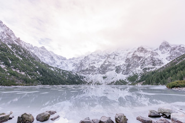 Vista mozzafiato sulle montagne innevate invernali e sul lago ghiacciato dell'altopiano