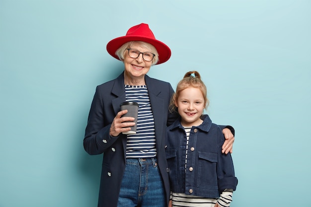 Vista orizzontale della nonna allegra indossa un cappello rosso elegante, giacca nera