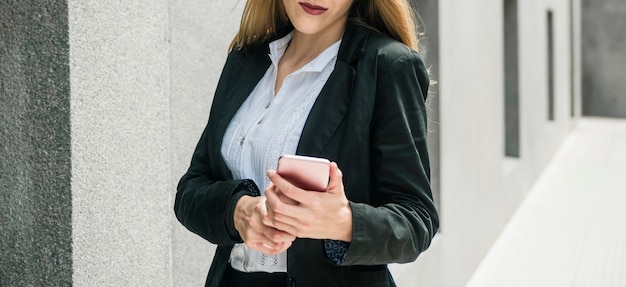 Vista panoramica della donna di affari che utilizza telefono cellulare all&#39;aperto