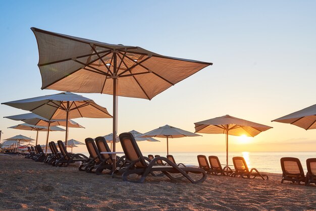 Vista panoramica della spiaggia di sabbia con lettini sul mare e sulle montagne al tramonto. Amara Dols Vita Luxury Hotel. Ricorrere. Tekirova Kemer. Tacchino.