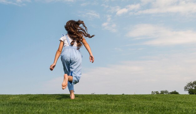 Vista posteriore bambina che corre a piedi nudi