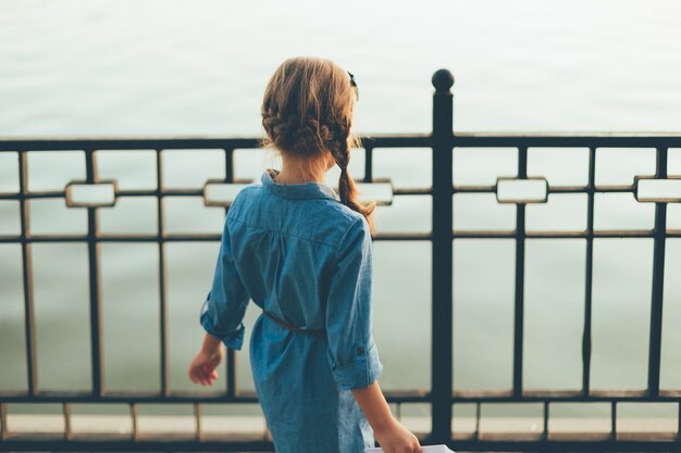 Vista posteriore del primo piano del bambino che osserva al lago