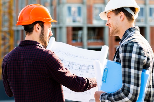 Vista posteriore del primo piano dell&#39;ingegnere e dell&#39;architetto che sorveglia la costruzione