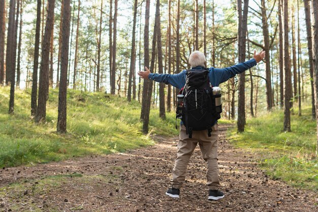 Vista posteriore dell'uomo più anziano con le braccia aperte per godersi la natura