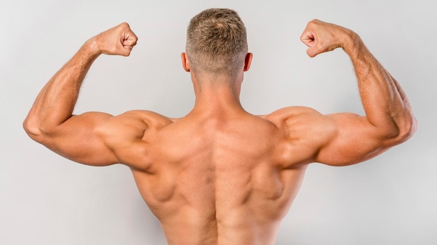 Vista posteriore dell'uomo senza camicia in forma che mostra i bicipiti