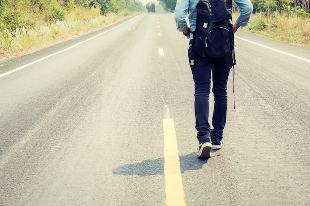 Vista posteriore della donna che cammina lungo la strada