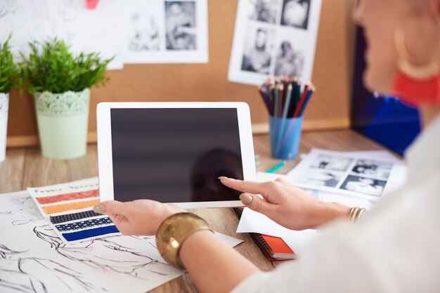 Vista posteriore della donna che utilizza la tavoletta digitale