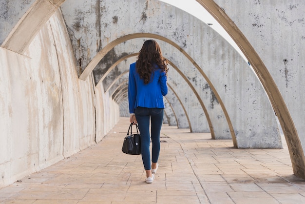 Vista posteriore della donna con la giacca blu a piedi