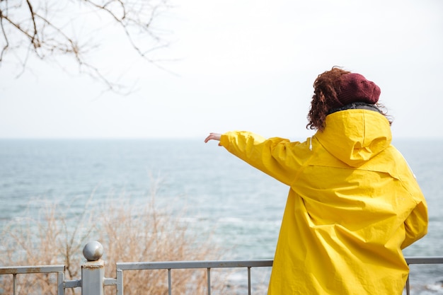 Vista posteriore della donna in impermeabile