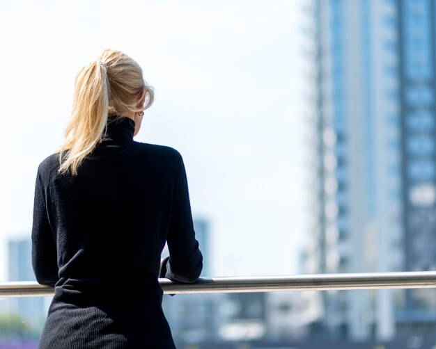 Vista posteriore della donna più anziana di affari che ammira la vista all'aperto