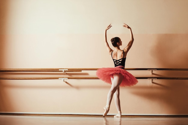 Vista posteriore della graziosa ballerina che prova allo studio di balletto Copia spazio