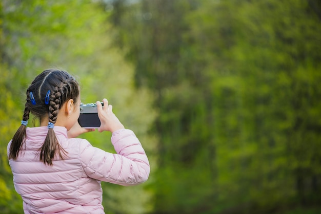 Vista posteriore della ragazza che utilizza la sua macchina fotografica