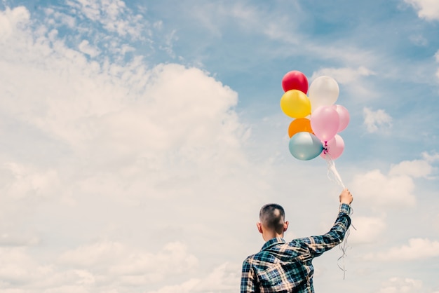 Vista posteriore di un adolescente che tiene gli aerostati