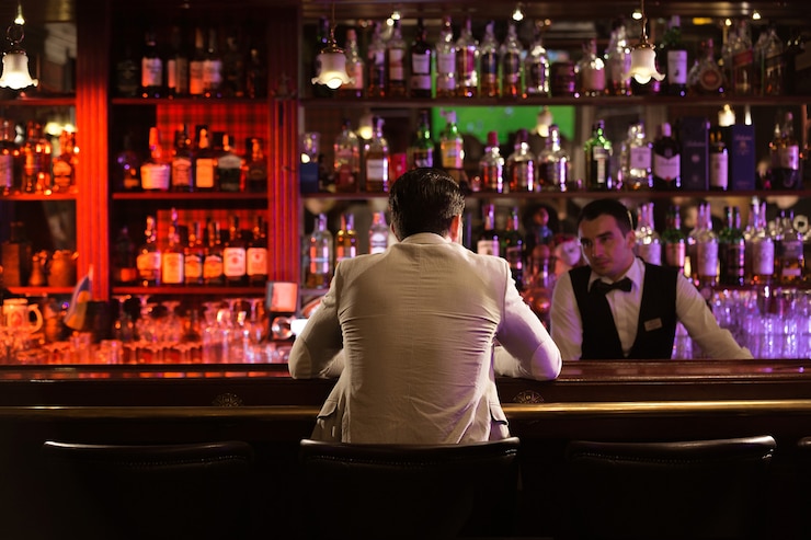 Foto gratuito vista posteriore di un uomo che ordina un drink a un barista