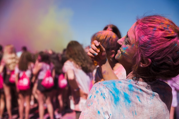 Vista posteriore di una giovane donna che gioca con la polvere di holi