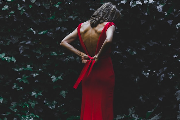 Vista posteriore donna che lega vestito