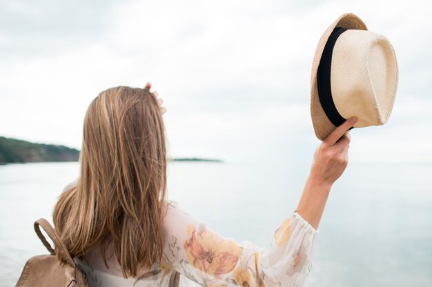 Vista posteriore donna con cappello vacanza