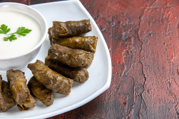 Vista ravvicinata anteriore del dolma foglia verde con yogurt sulla superficie scura