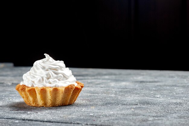 Vista ravvicinata anteriore piccola torta cremosa al forno deliziosa isolata su grey