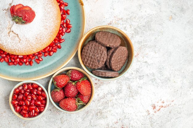 Vista ravvicinata dall'alto ciotole di biscotti diversi tipi di torta ai frutti di bosco con fragole